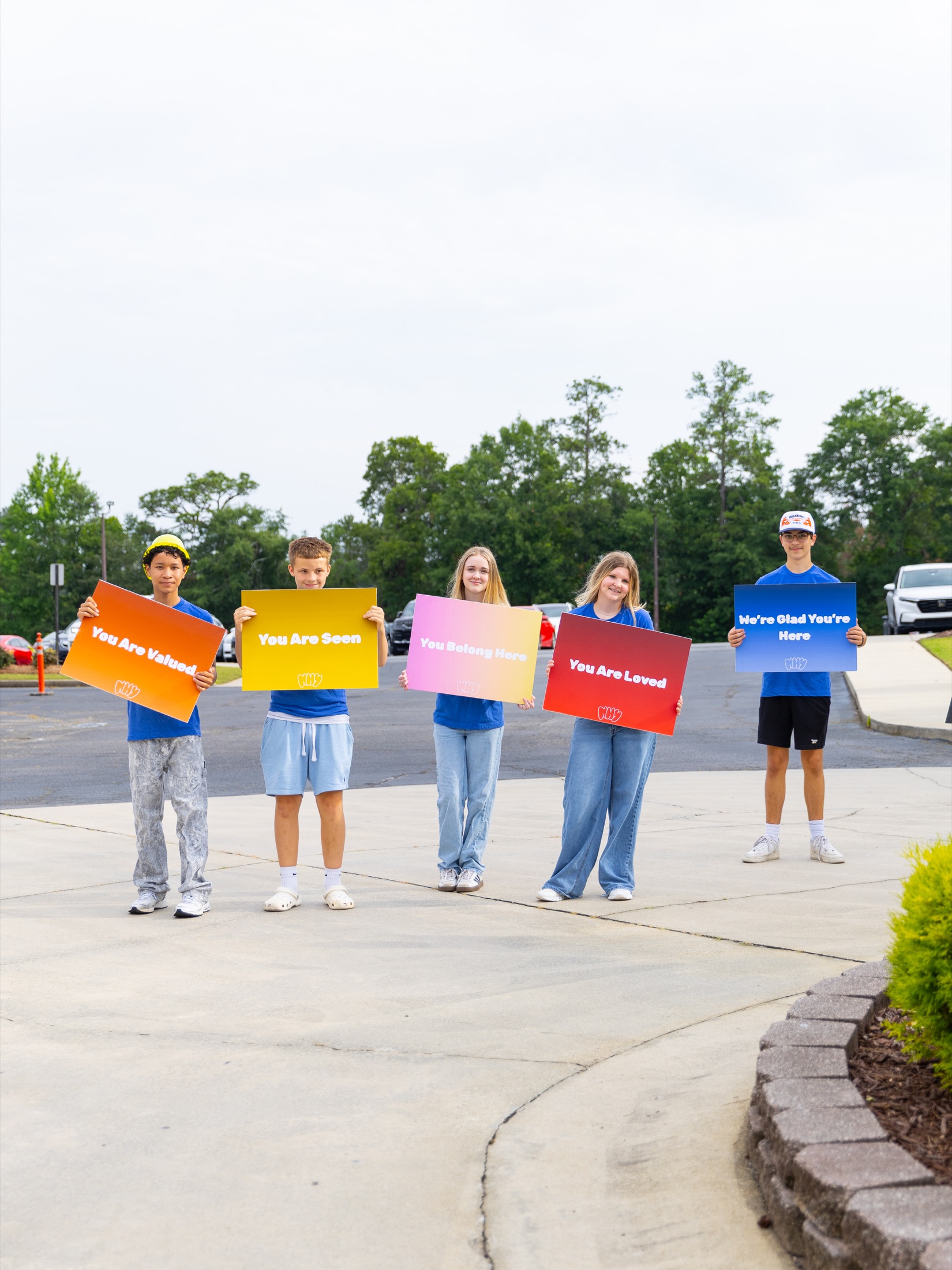 New Hope volunteers holding colorful welcome signs outside
