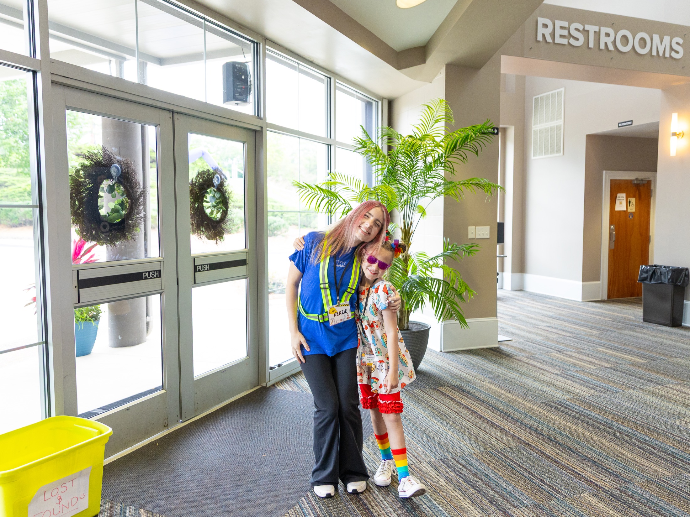 A New Hope Kids volunteer guiding a child through the secure entrance